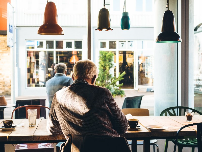 old man in cafe reading